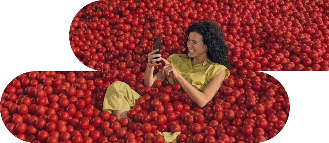 Mujer con su móvil sobre un fondo de tomates